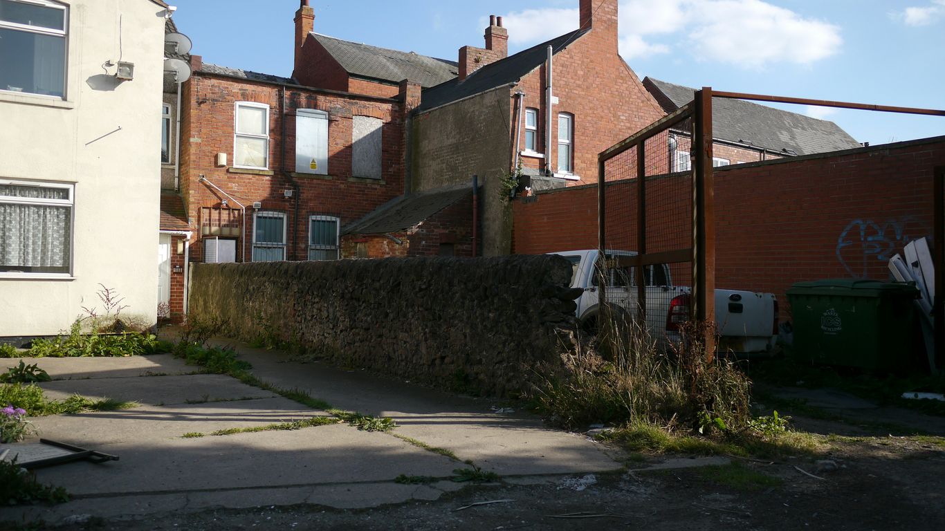 How Much Does a Home Extension Cost in Manchester? a brick building with a fence in front of it