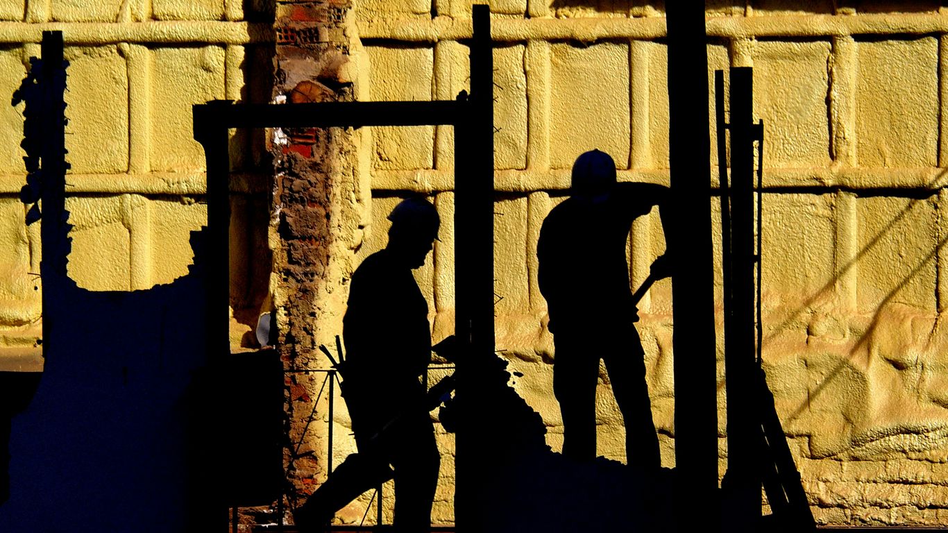 silhouette of 2 men standing on a ladder