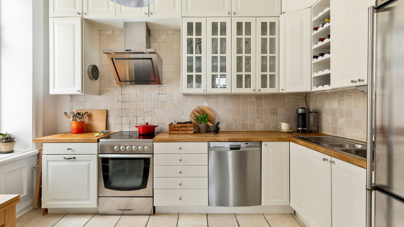 A kitchen with white cabinets and stainless steel appliances