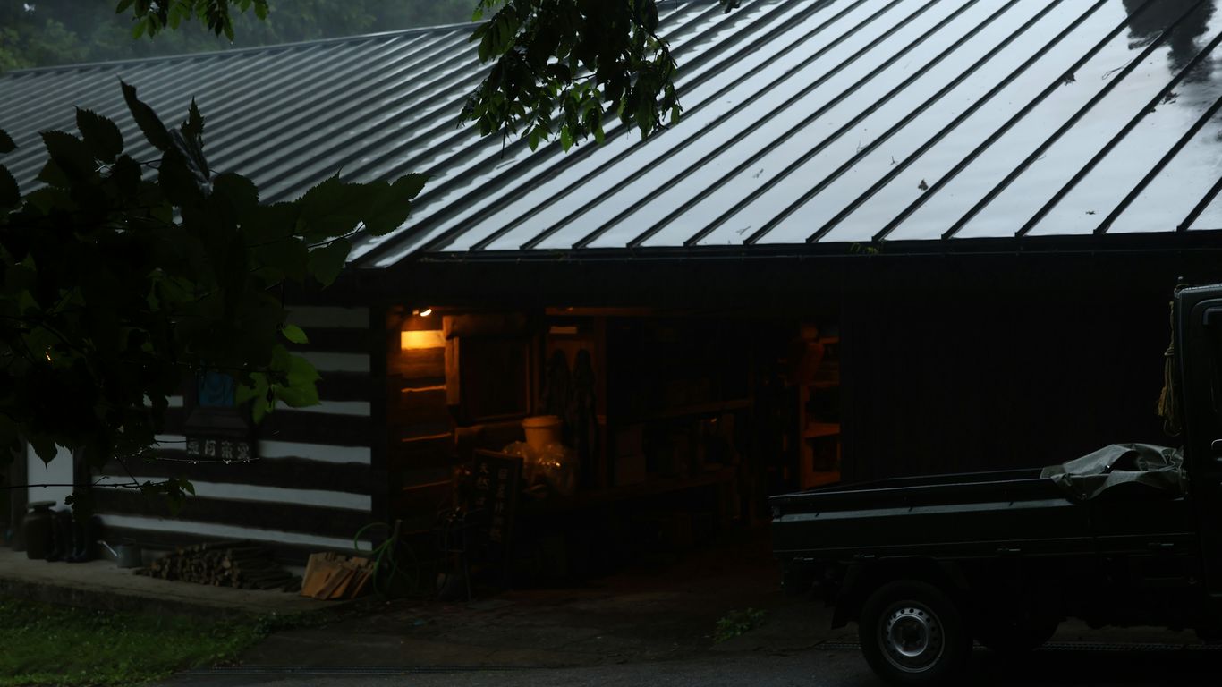 A rustic cabin is seen in the rain.